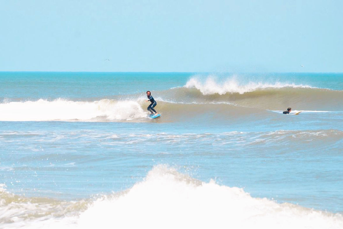 Surfing outer banks beach SAGA Realty and Construction